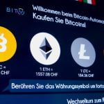 FILE PHOTO: The exchange rates and logos of Bitcoin, Ether, Litecoin and Monero are seen on the display of a cryptocurrency ATM in Zurich